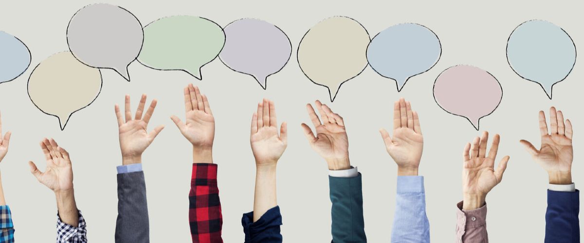 Hände strecken sich nach farbigen Sprechblasen