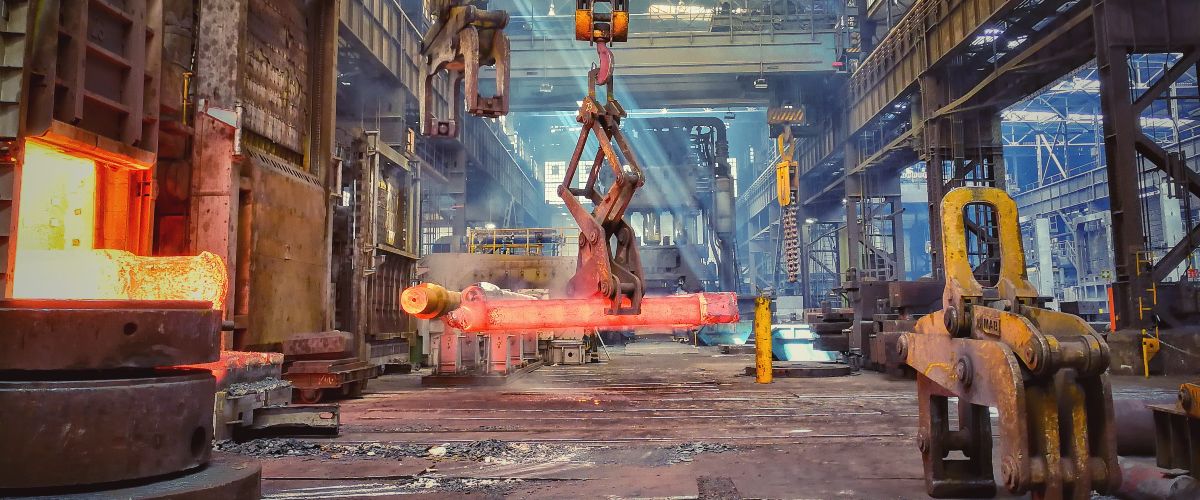 Vorgeschmiedeter Stab mit ca. 28 Tonnen Gewicht zum Auflegen auf den Schmiedeofen 23 (vorn links); im Hintergrund steht die Wasserhydraulische 60MN Freiformschmiedepresse.